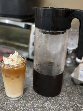 the cold brew coffee maker and an iced coffee next to it