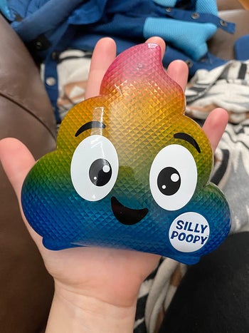reviewer holding the rainbow poop toy