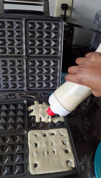 reviewer pouring batter into waffle maker using batter dispenser