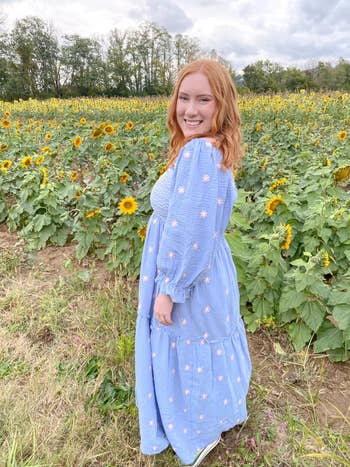 Person successful  a floral formal  stands successful  a sunflower field, smiling