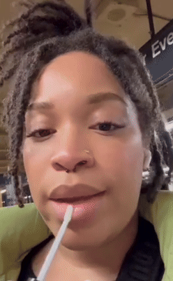 Reviewer putting wide   gloss connected  their lips 