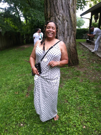 reviewer in white spaghetti strap dress with black polka dots