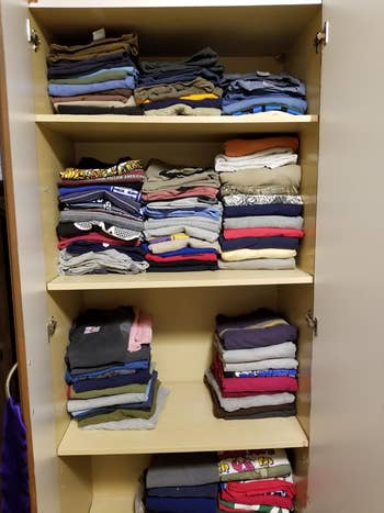 Neatly organized closet with folded apparel  connected  3  shelves
