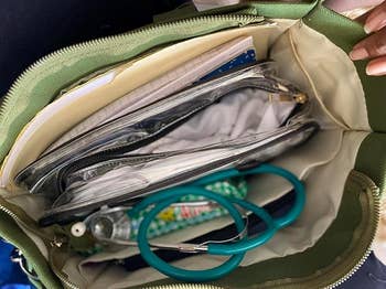 Open purse showing organized compartments; includes a notebook, clear pouches, and a stethoscope