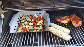 reviewer photo of cut up vegetables being cooked in the grill pan, next to a few ears of corn on a grill