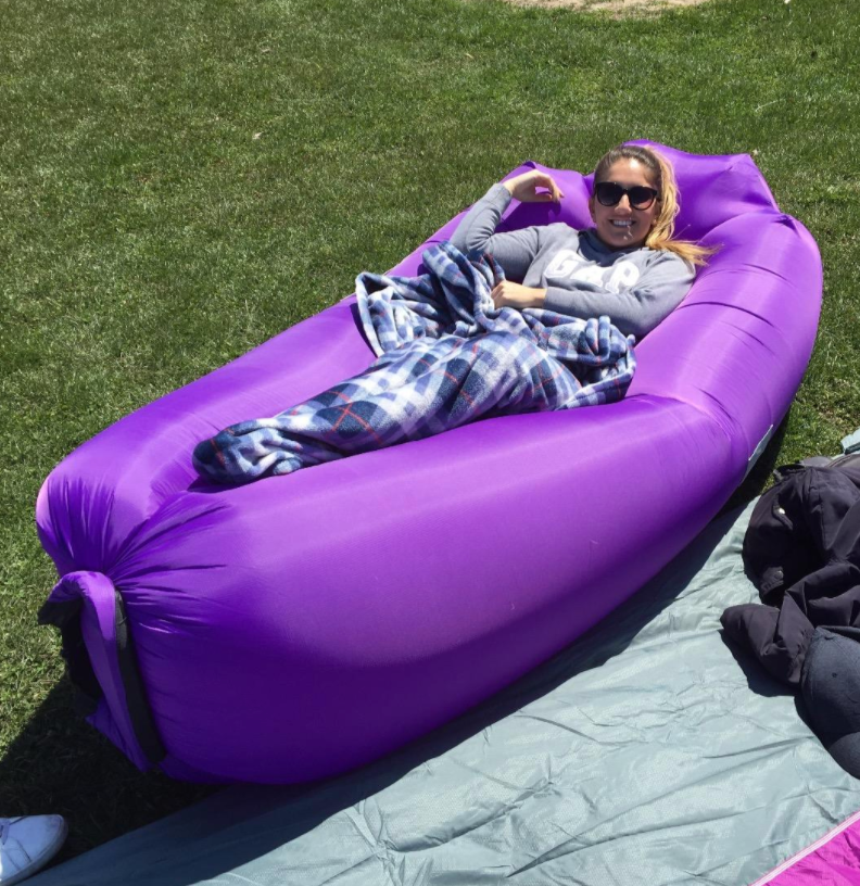 reviewer on the inflatable lounger wrapped in a blanket