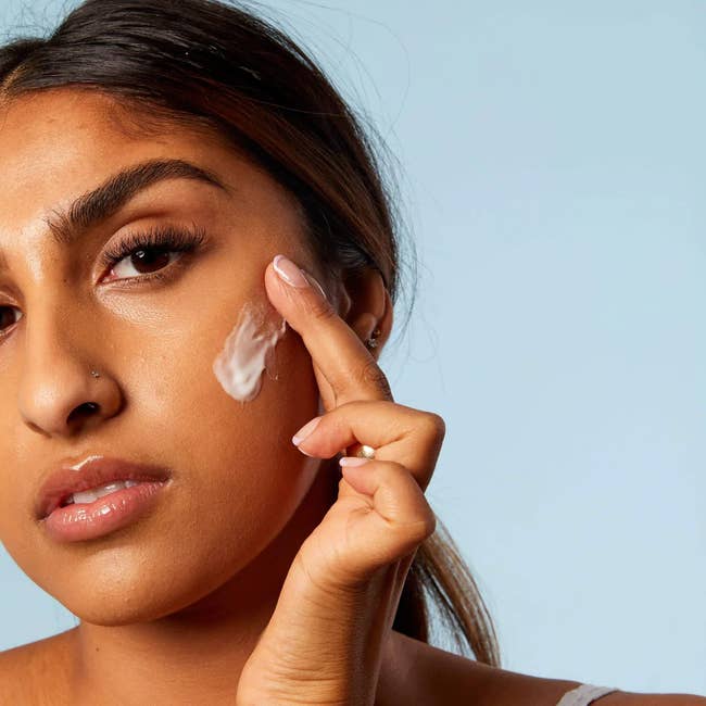 a model applying the moisturizer to their face