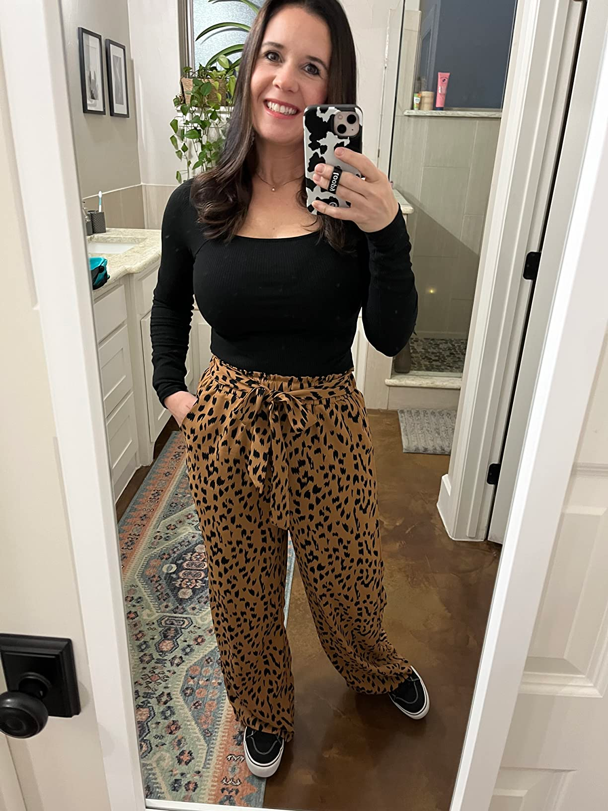 Reviewer successful  a achromatic  apical  and patterned pants taking a reflector  selfie successful  a bathroom, showcasing a comfy  outfit