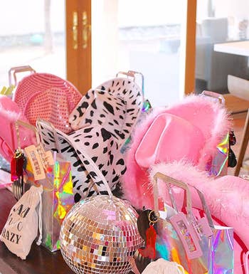 reviewer's disco ball on a table with a bunch of pink hats and gift bags