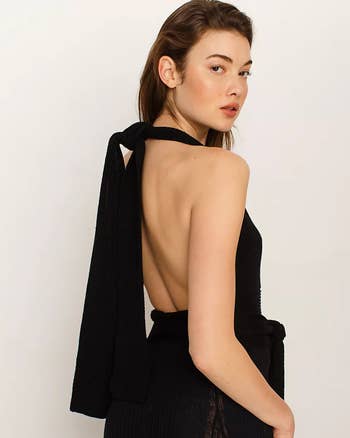 Model wearing the tank in black with the straps tied in a halter