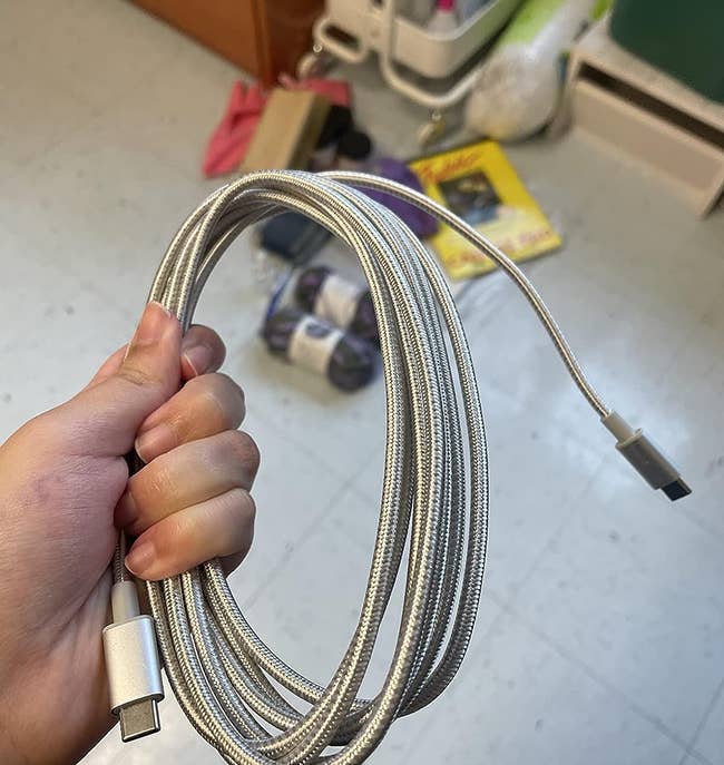 reviewer holds up the charging cable