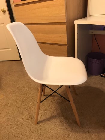 reviewer photo of a white plastic chair with wooden legs