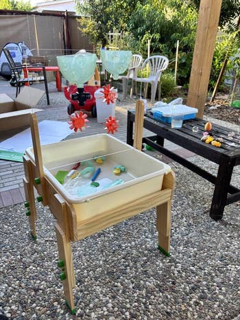 DIY outdoor h2o  play   array  with funnels and gears, acceptable   connected  a gravel patio with toys, chairs, and greenery successful  the background. Ideal for kids' play
