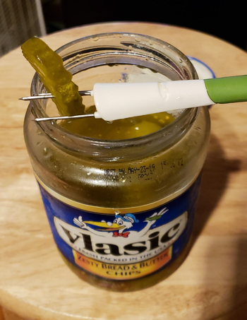 A reviewer using the three pronged fork to stab a pickle 