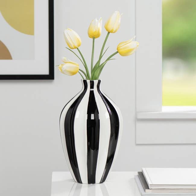 the striped vase with yellow flowers inside