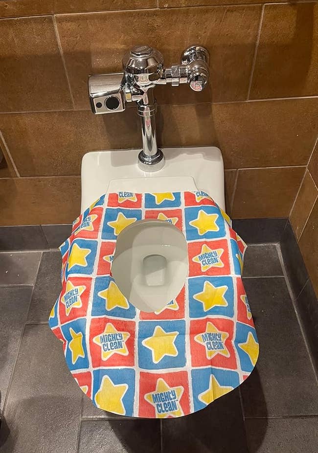 a public toilet with reviewers disposable toilet seat cover on it