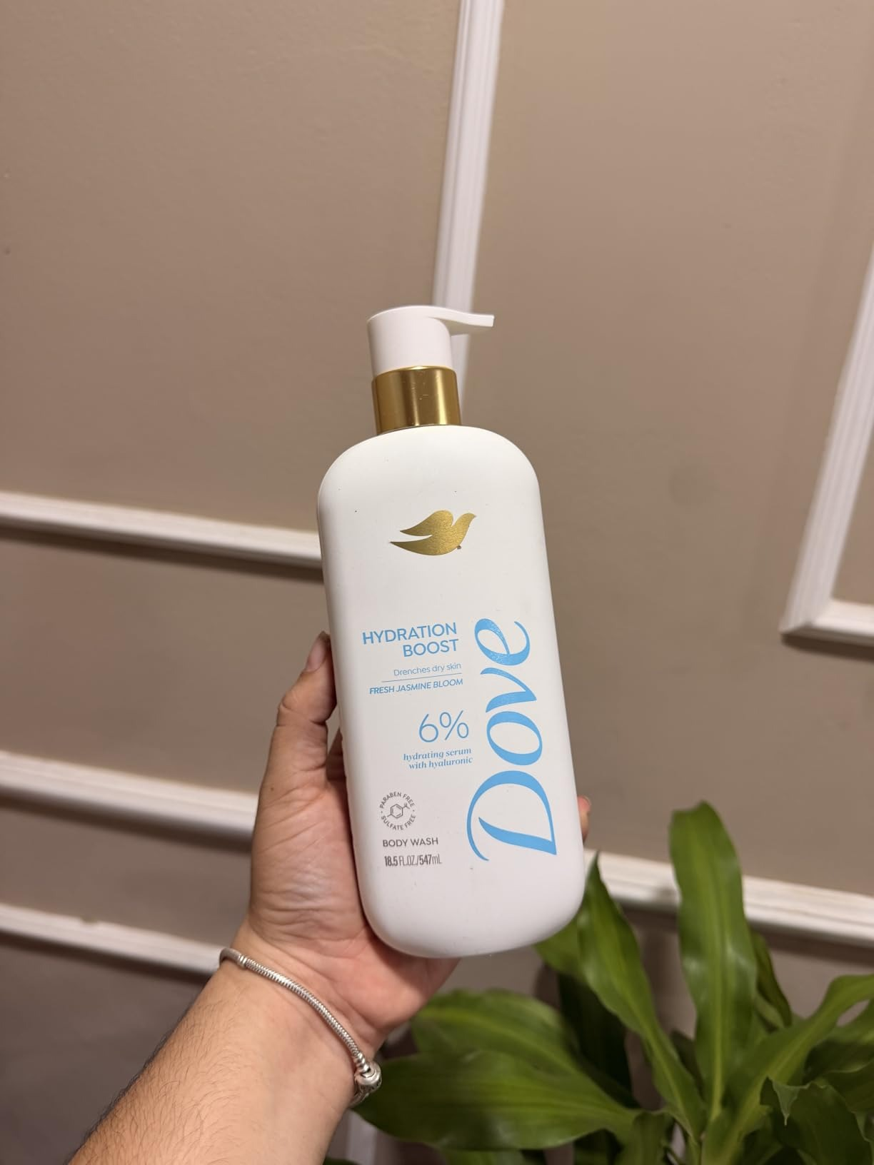 Hand holding a Dove Hydration Boost Body Wash with a pump dispenser, suitable for moisturizing tegument  care