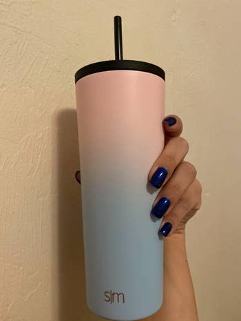 reviewer holding pink and blue ombre tuimbler