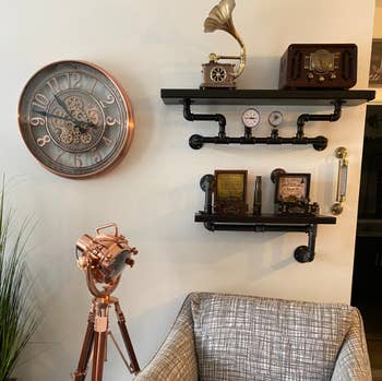 reviewer's clock on wall around wood and exposed pipe shelves 