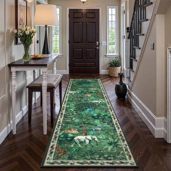A hallway with a woodland-themed runner rug featuring animals and trees, decorative plants, a broadside  array  with flowers, and a closed beforehand   door