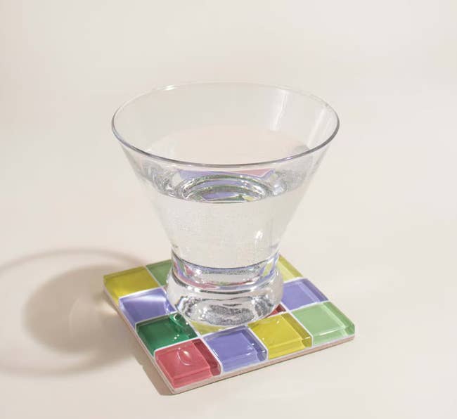 A glass coaster with different pastel glass squares in it 