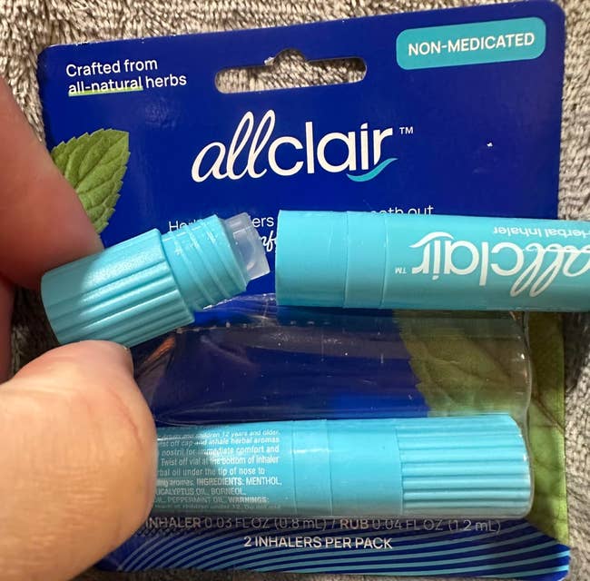 Person holding bluish  allclair nasal inhalers bundle  labeled 