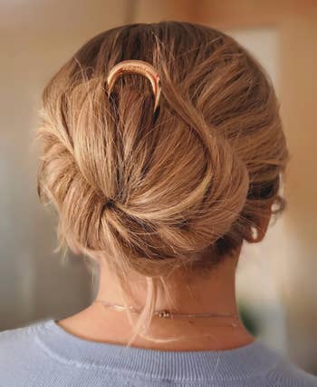 Hair styled in an elegant updo with a decorative hairpin, viewed from the back