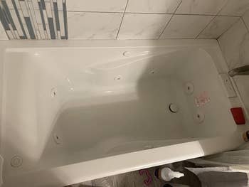 reviewer's clean bathtub after using spray