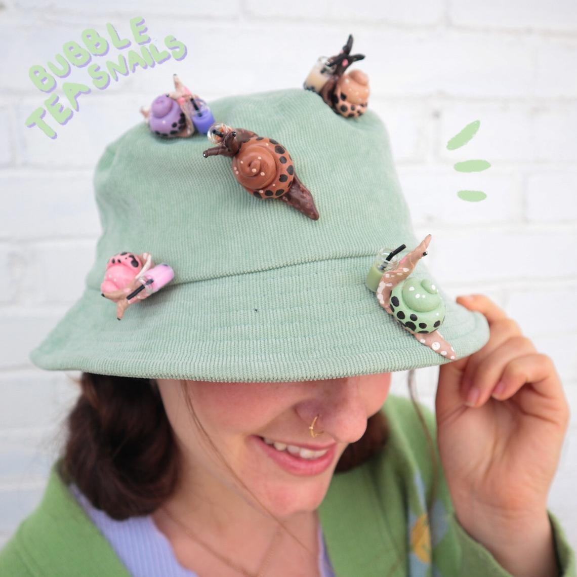 bucket hat covered in snails in different colors with shells that have little circles that look like boba