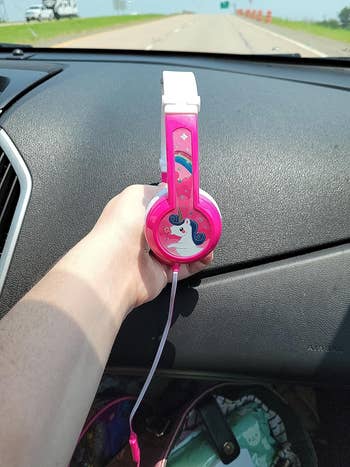 reviewer holding their childs headphones