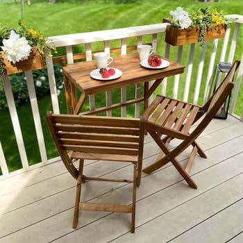a wooden balcony table with two chairs