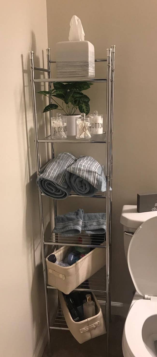 Reviewer image of silver metal six-tier freestanding shelf next to toilet