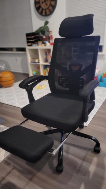 a reviewer's black chair with the foot rest out
