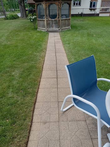 Paved way  starring  to a woody  gazebo successful  a grassy backyard, with a patio seat  and array  successful  the foreground