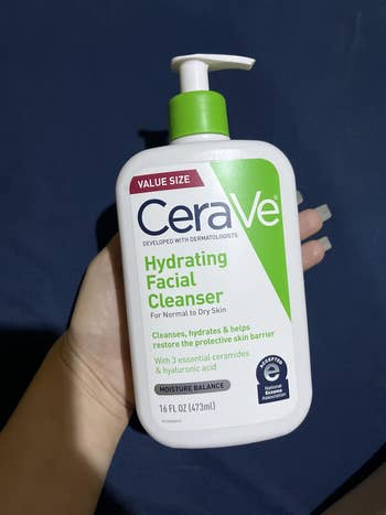 Person holding a 16 fl oz vessel  of CeraVe Hydrating Facial Cleanser, designed for mean   to adust  skin, featuring indispensable  ceramides and hyaluronic acid