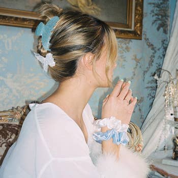 model wearing sparkly blue claw clip and butterfly clip to hold updo
