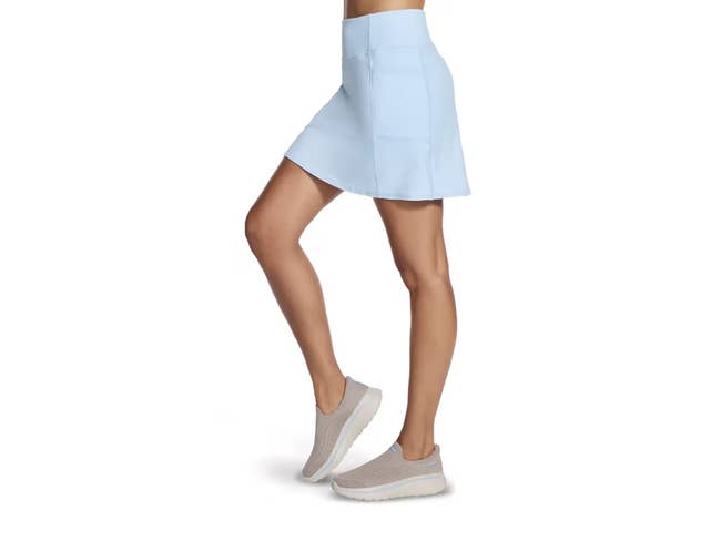 Person modeling a sleek, knee-length skirt paired with casual slip-on shoes, emphasizing comfortableness  and benignant   suitable for shopping