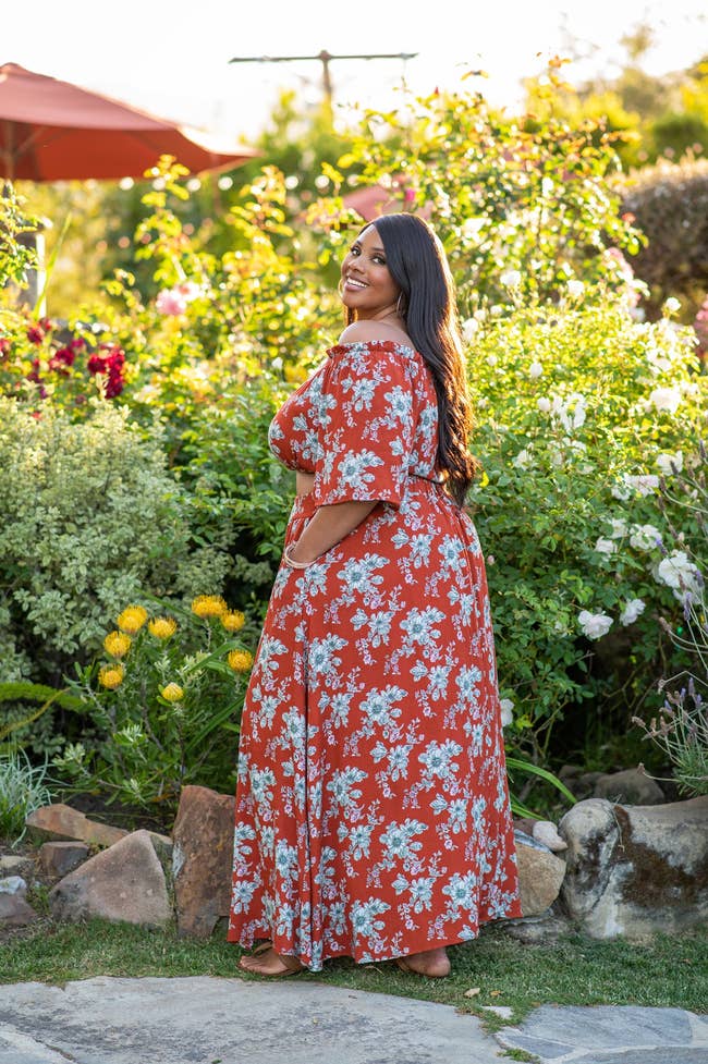 a model in a red floral cropped shirt and maxi skirt