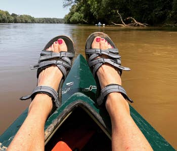 reviewer in gray Teva sandals on a canoe