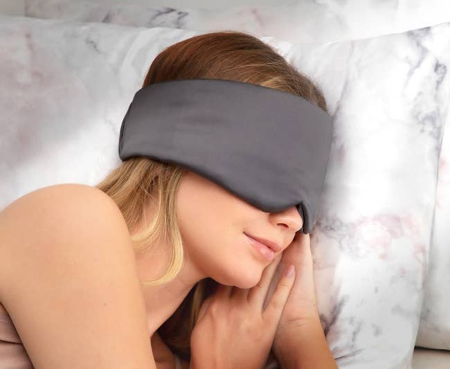 A model in the grey eye mask which wraps around instead of having an elastic band