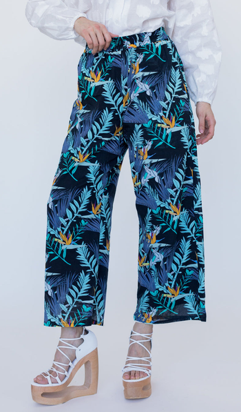 a model wearing the pants featuring a blue and black palm print 