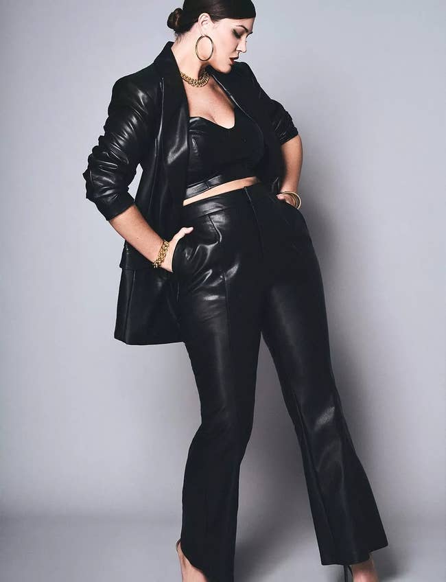 model wearing the black flare leg faux leather pants with a leather blazer and leather crop top