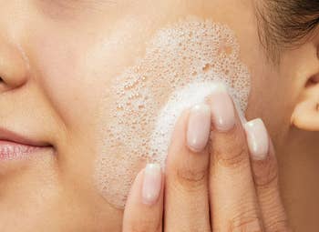 Close-up of a person's look with a gentle facial cleanser being applied successful circular motions, showcasing skincare routine