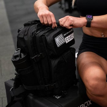 someone unzipping black gym backpack