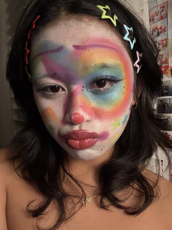 Person with colorful clown constitution and star-shaped hairsbreadth clips poses for a selfie
