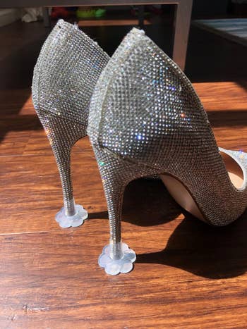 A pair of sparkly high-heeled shoes with heel protectors