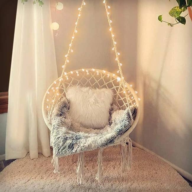 The hanging chair lit up and with a blanket on it