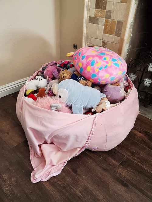 Reviewer's photo showing a pile of stuffed animals inside the bean bag cover
