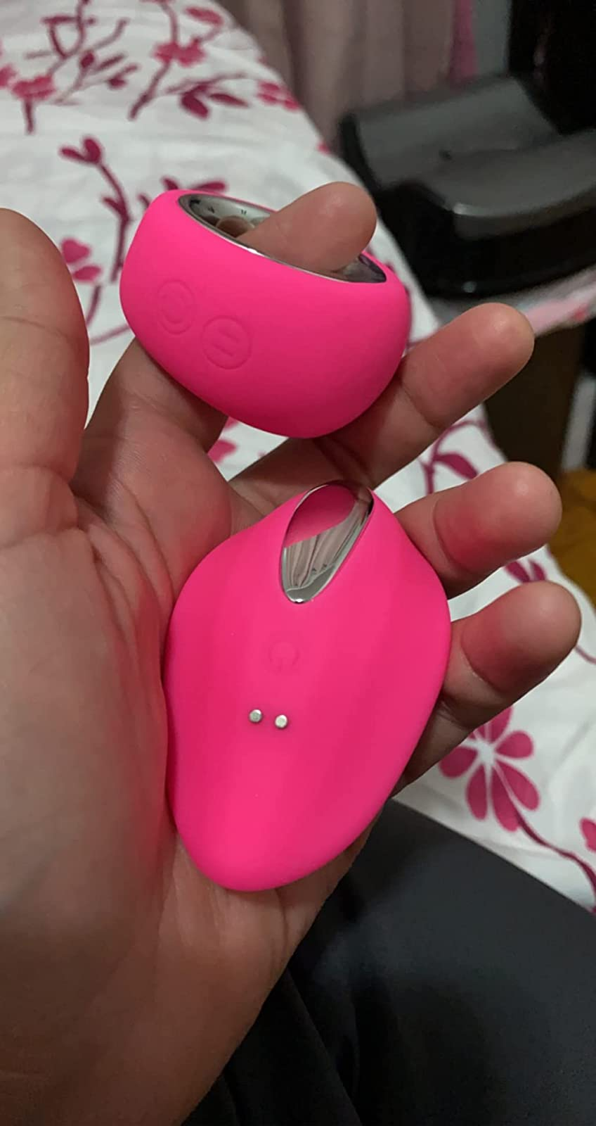 Reviewer holding pink panty vibrator and round wireless remote