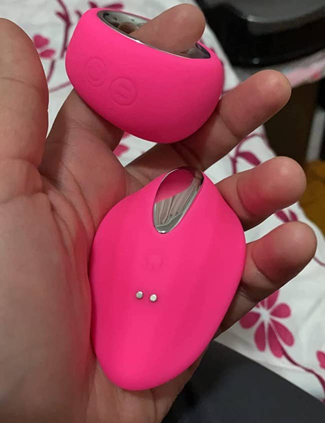 Reviewer holding pink panty vibrator and round wireless remote